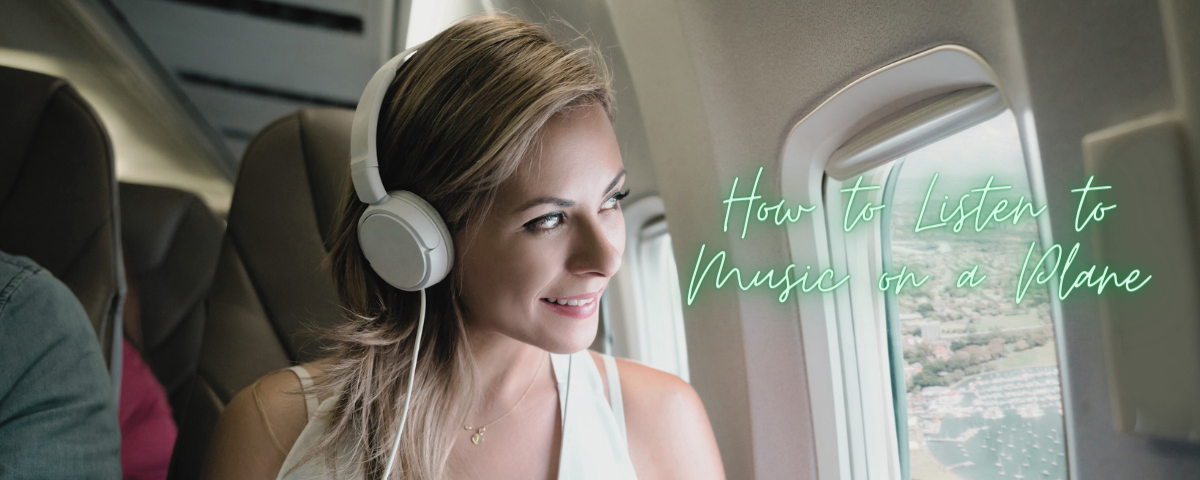 smiling woman looking out of plane window wearing headphones