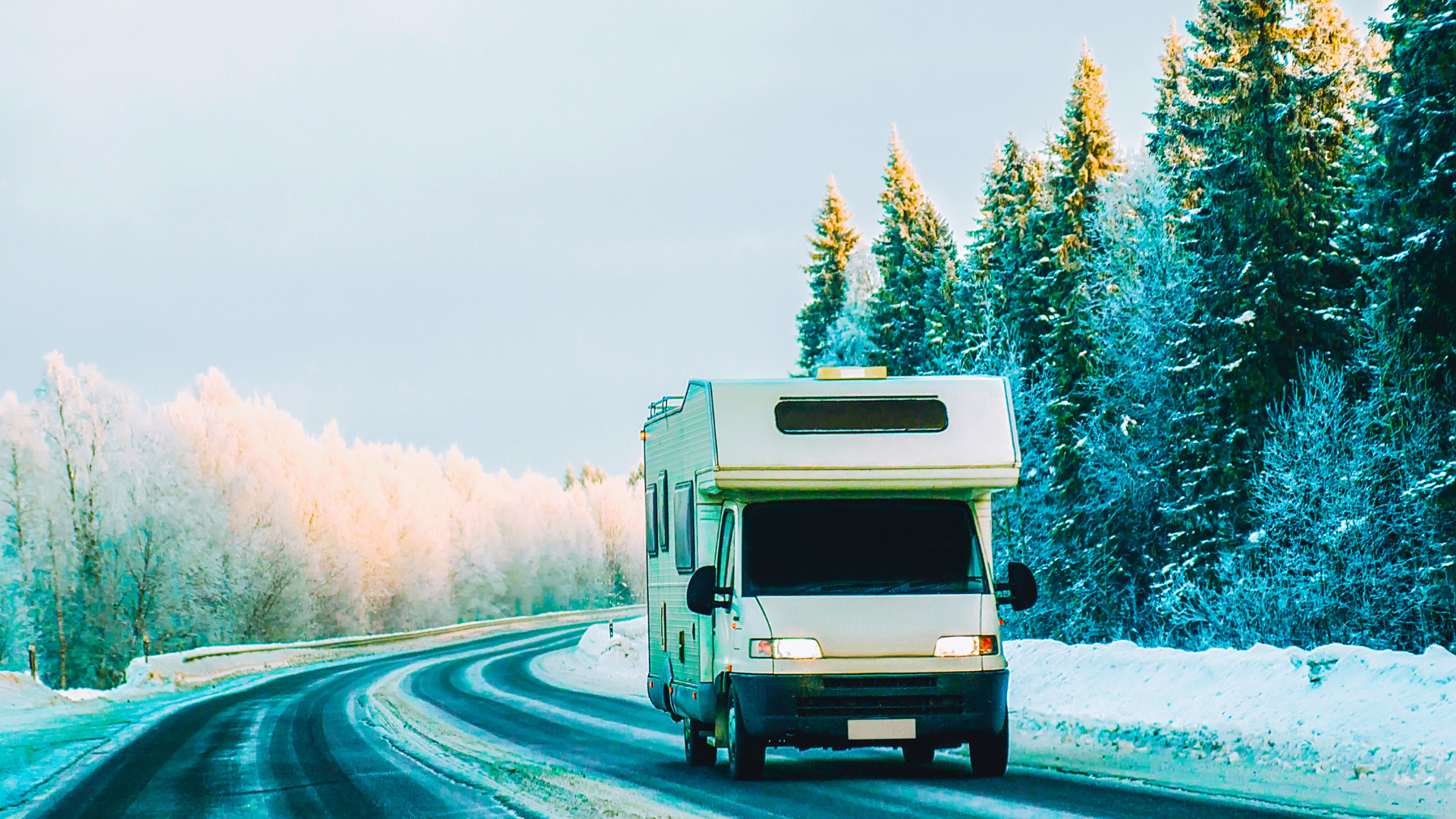 camper van driving through winter forest